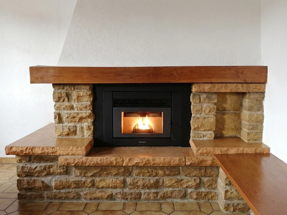 Intérieur chalet alpin luxueux, cheminée suspendue design noire type « focale » à foyer ouvert central, flammes vives sur bûches
