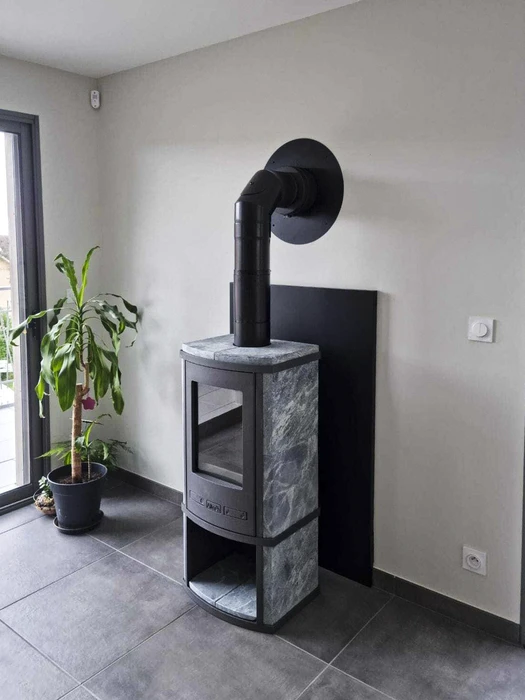 Poêle à bois design cylindrique noir mat, modèle contemporain à corps tubulaire, vitrage panoramique incurvé révélant un feu actif