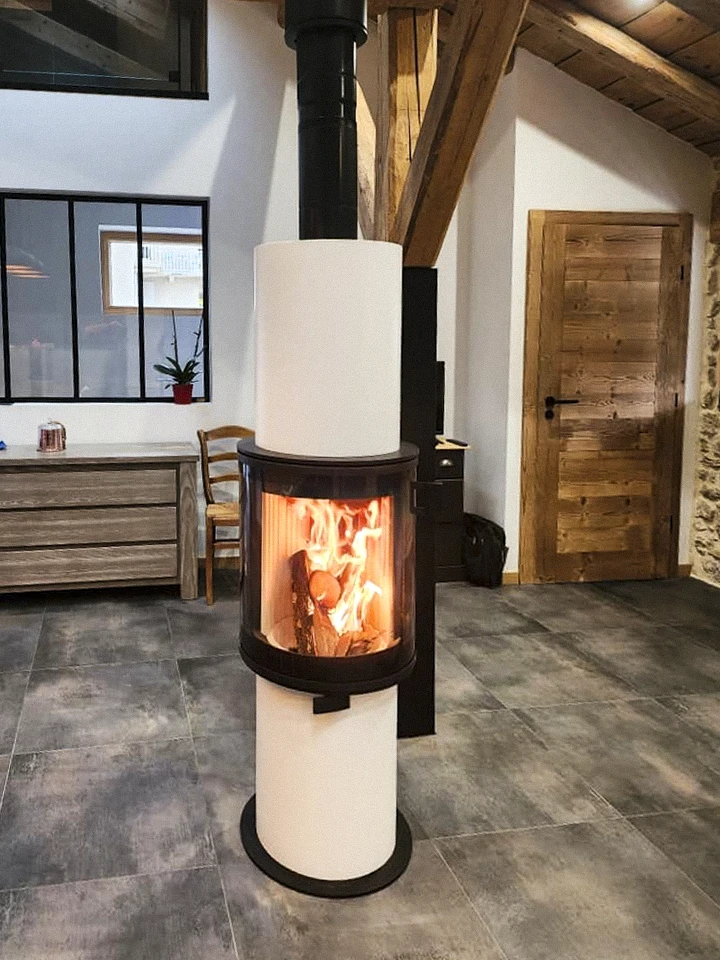Intérieur chaleureux avec poêle à bois en fonte noire allumé, flammes visibles à travers vitre ornementée