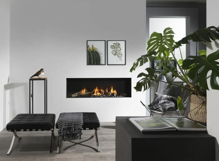 Salon de luxe avec cheminée à gaz en fonctionnement, canapés gris et fauteuils beiges disposés autour d'une table basse